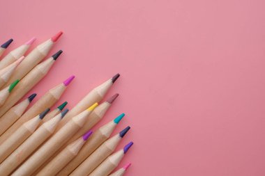 Pembe arkaplanı olan renkli kalem ve kalem 