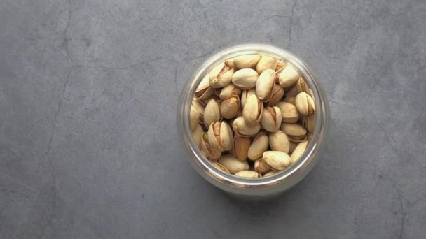 Vista superior de los pistachos en un frasco sobre la mesa — Vídeo de stock