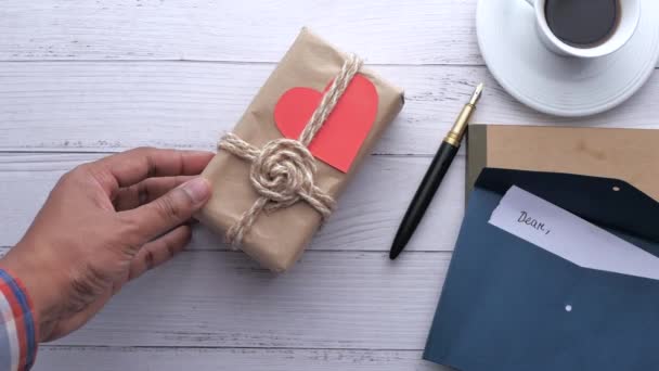 Overhead Hand legt Geschenkbox auf den Tisch. — Stockvideo