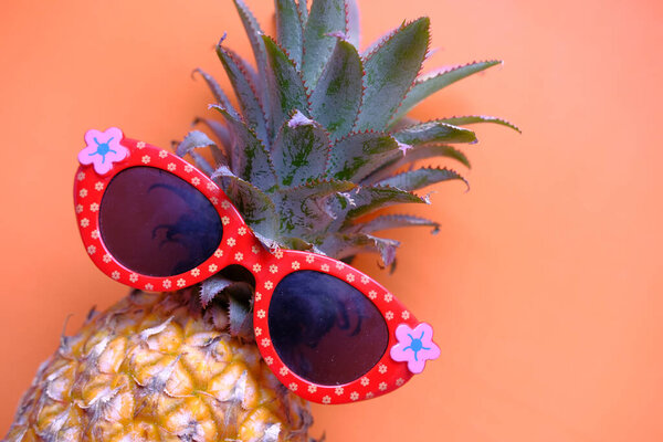 Closeup of a pineapple wearing a pair of eyeglasses.