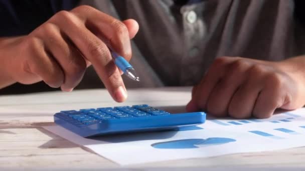 Primer plano del joven usando la calculadora — Vídeo de stock