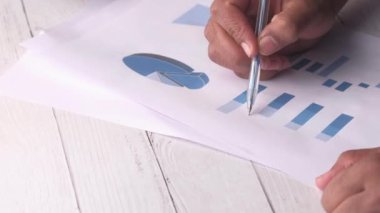 Ofisteki bar çizelgesini inceleyen adamın elini kapat. 