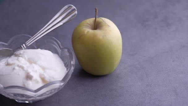 Крупним планом йогурт і яблуко на столі — стокове відео