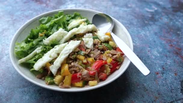 Närbild av sallad och tonfisk på tallrik med hantel på bordet — Stockvideo