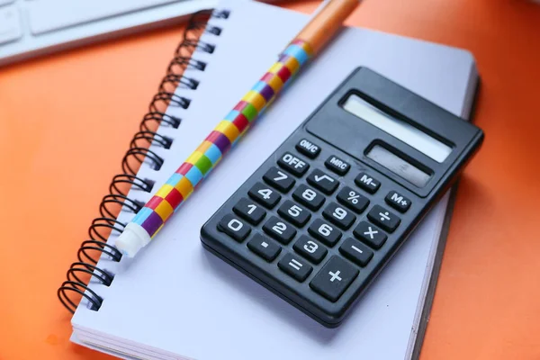 Primer plano de la calculadora, bloc de notas y pluma sobre fondo rosa — Foto de Stock