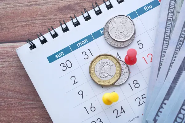 Concepto de plazo con push pin, moneda y dinero en efectivo en la fecha del calendario — Foto de Stock