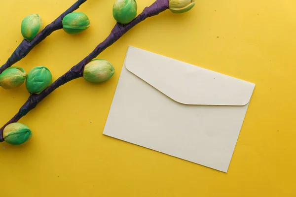 Close-up van gele kleur envelop en bloem op gele achtergrond — Stockfoto
