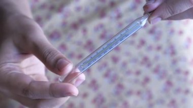 top view of women hand holding thermometer.