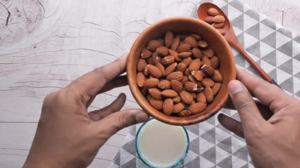 Закрыть свежий миндаль и молоко на столе — стоковое видео