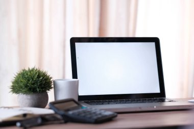 Ofis masasında beyaz ekranlı dizüstü bilgisayar 