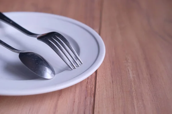 Close up of Empty plate, fork, spoon on table — Stock Photo, Image