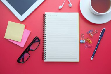 Not defteri dijital tabletinin üst görünümü, kırmızı arkaplanda çay 