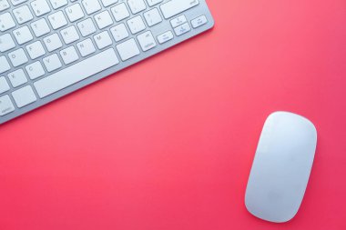 Pembe arkaplanda bilgisayar faresi ve klavyesi 