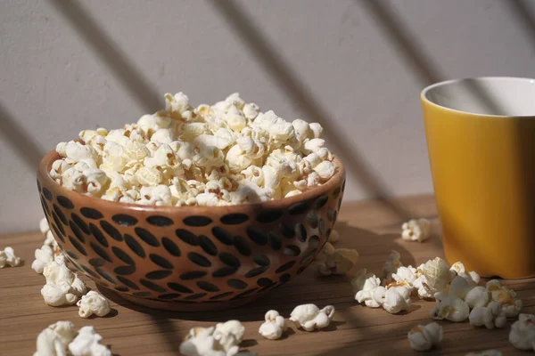 Popcorn v dřevěné míse na stole brzy ráno — Stock fotografie