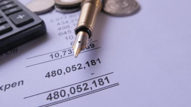 Крупный план бухгалтерских данных, калькулятора монет и ручки на бумаге — стоковое видео