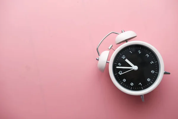 Reloj despertador de color sobre fondo rosa, vista superior . —  Fotos de Stock