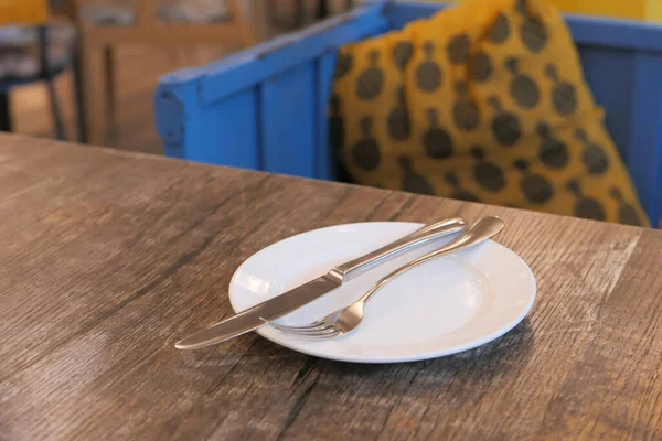 Fechar de Placa vazia, garfo, colher na mesa — Fotografia de Stock