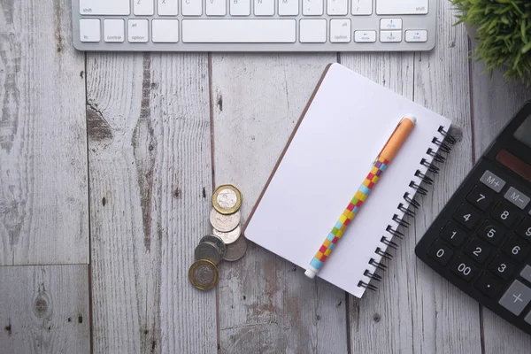 Vue du haut de la calculatrice, bloc-notes et stylo sur fond rose — Photo