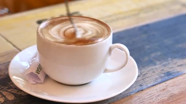 Jovem mulher mexe xícara de café com colher . — Vídeo de Stock