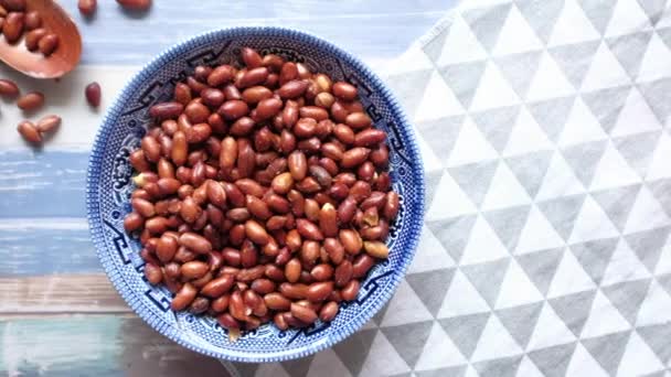 Vista superior de cacahuete i na bowl en la mesa — Vídeos de Stock