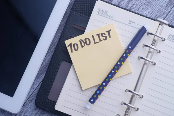 Vista superior de la lista de cosas por hacer en el bloc de notas en la tabla offie . —  Fotos de Stock