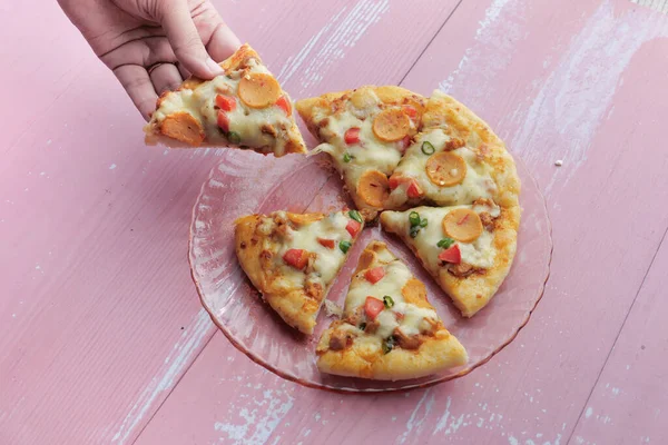 Fetta di pizza e insalata in un piatto sul tavolo — Foto Stock