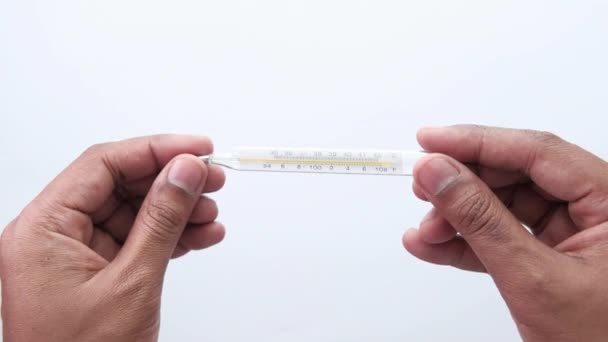 Mann hält Thermometer isoliert auf weiß — Stockvideo