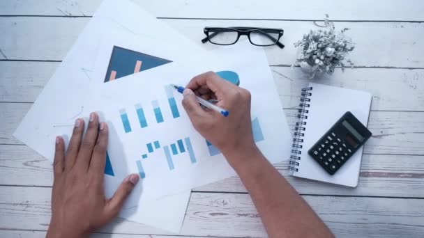 Close up of man hand analyzing bar chart on office desk — Stock Video