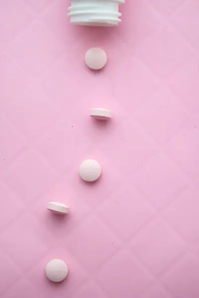 Ροζ χάπια χυθεί σε ροζ φόντο, κοντά . — Φωτογραφία Αρχείου