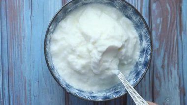 Kırsal ahşap bir masada ahşap bir kasede Yunan yoğurdu..