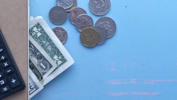 Närbild av stapel av mynt, kontanter och plånbok på bordet. — Stockvideo