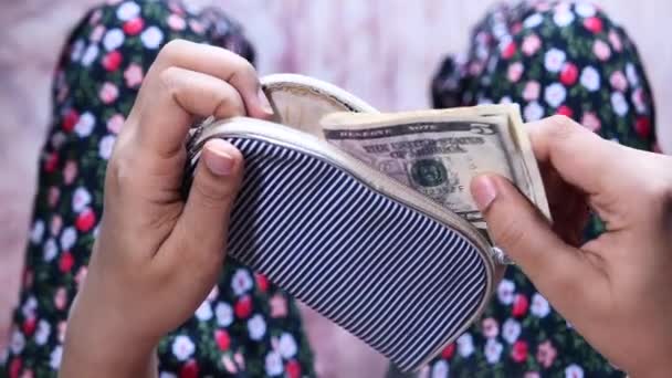 Женщина вытаскивает долларовые купюры из кармана — стоковое видео