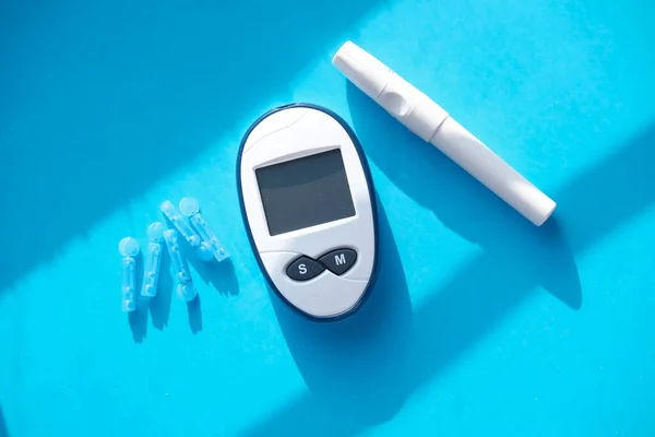  Mavi arka planda şeker hastalığı, haplar için kan şekeri ölçümü 