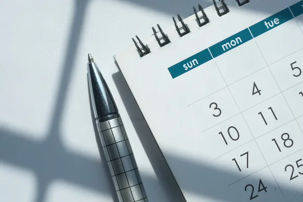 Top view of calendar, pen on white background — Stock Photo, Image