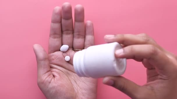 Крупный план таблеток, льющихся на ладонь женщин — стоковое видео