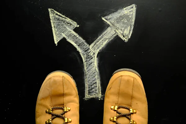 Zapatos y flechas apuntando en diferentes direcciones en el suelo, elección en la vida . — Foto de Stock