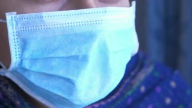 Tıbbi yüz koruma maskesi takan genç bir kadın.