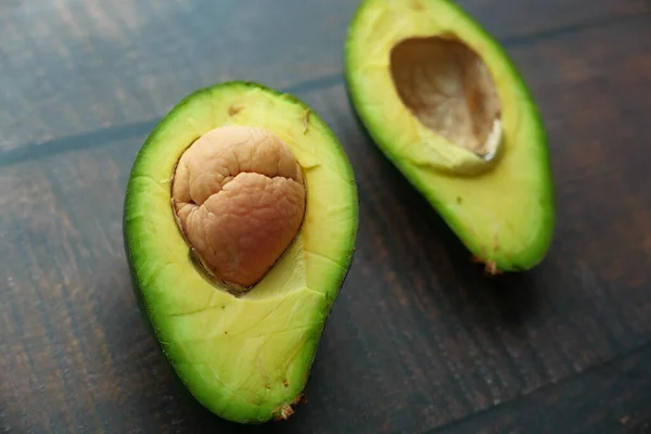 Close-up van plak avocado op houten tafel. — Stockfoto