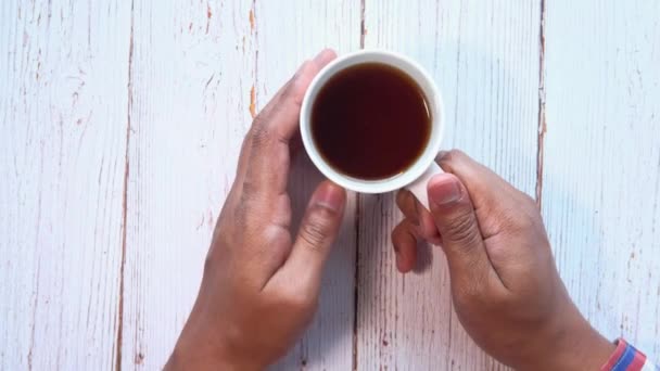 Man hand holding cup of tea on table. — Stock Video