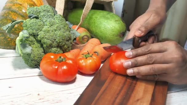 도마 위에서 손으로 토마토를 자르는 모습 — 비디오