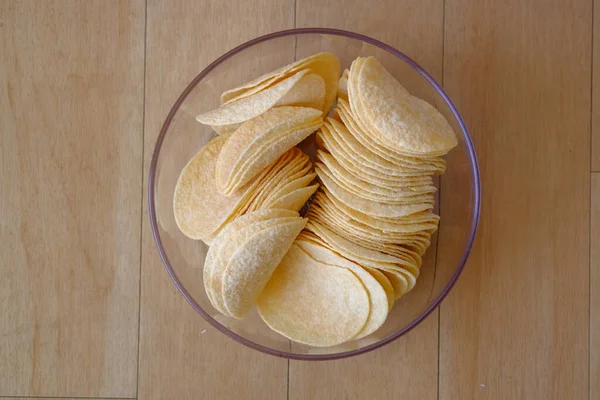 Вид сверху на картофельные чипсы в миске на столе . — стоковое фото