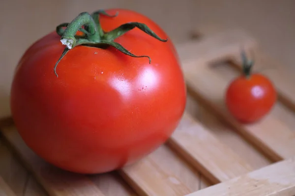 Deux tomates rouges sur la table, petites et grandes . — Photo