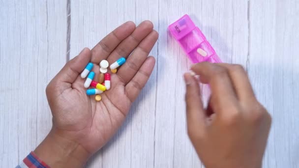 Hombre mano poner la medicina en una caja de pastillas — Vídeo de stock