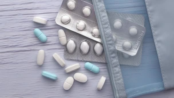 Witte kleur pillen morsen uit container op witte achtergrond, close-up — Stockvideo