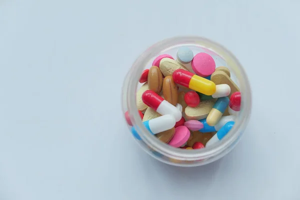 Κοντινό πλάνο πολύχρωμα χάπια σε ένα δοχείο στο τραπέζι — Φωτογραφία Αρχείου