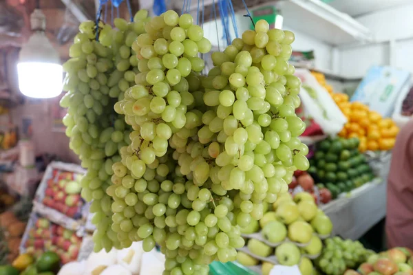 Racimos frescos maduros de uvas oscuras y blancas en el mostrador . — Foto de Stock