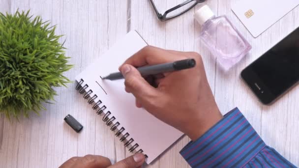 Vista superior del hombre escribiendo palabra cuarentena en el bloc de notas . — Vídeos de Stock