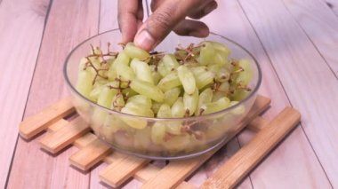 Erkeklerin ellerinin üzümlü meyve yemesine yakın..