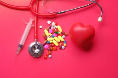 uyuşturucu, steteskop, kalp şekli ve renk arkaplanındaki şırınga.