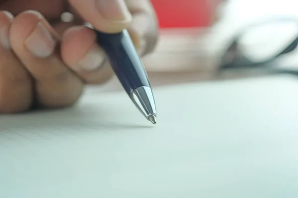 Fechar a mão masculina escrevendo com caneta sobre papel — Fotografia de Stock